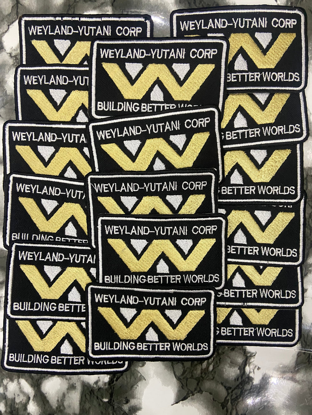 Multiple patches with Weyland-Yutani Corp logo and text on a textured background