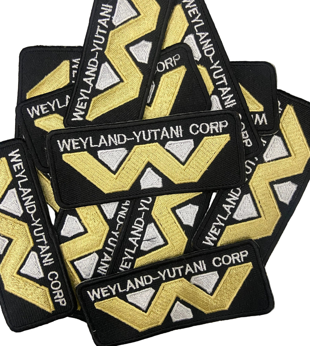Multiple 'Weyland-Yutani Corp' patches on a marble surface