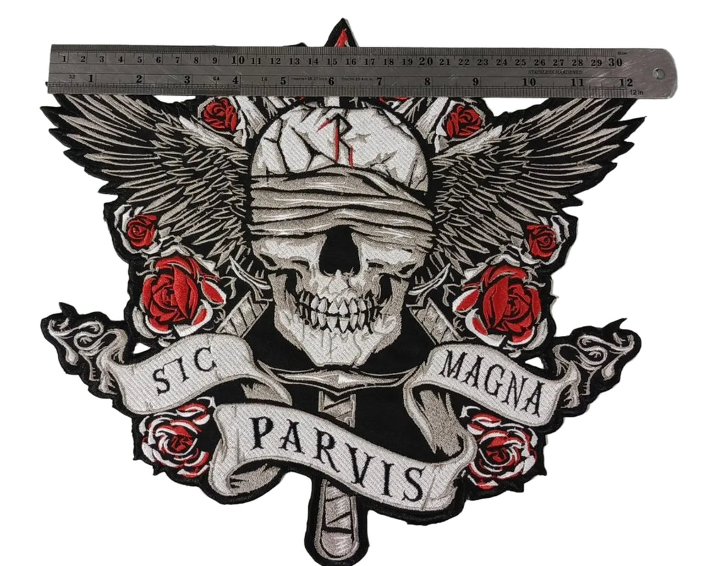 Skull with roses and wings on a concrete wall with 'Sic Parvis Magna' text.
