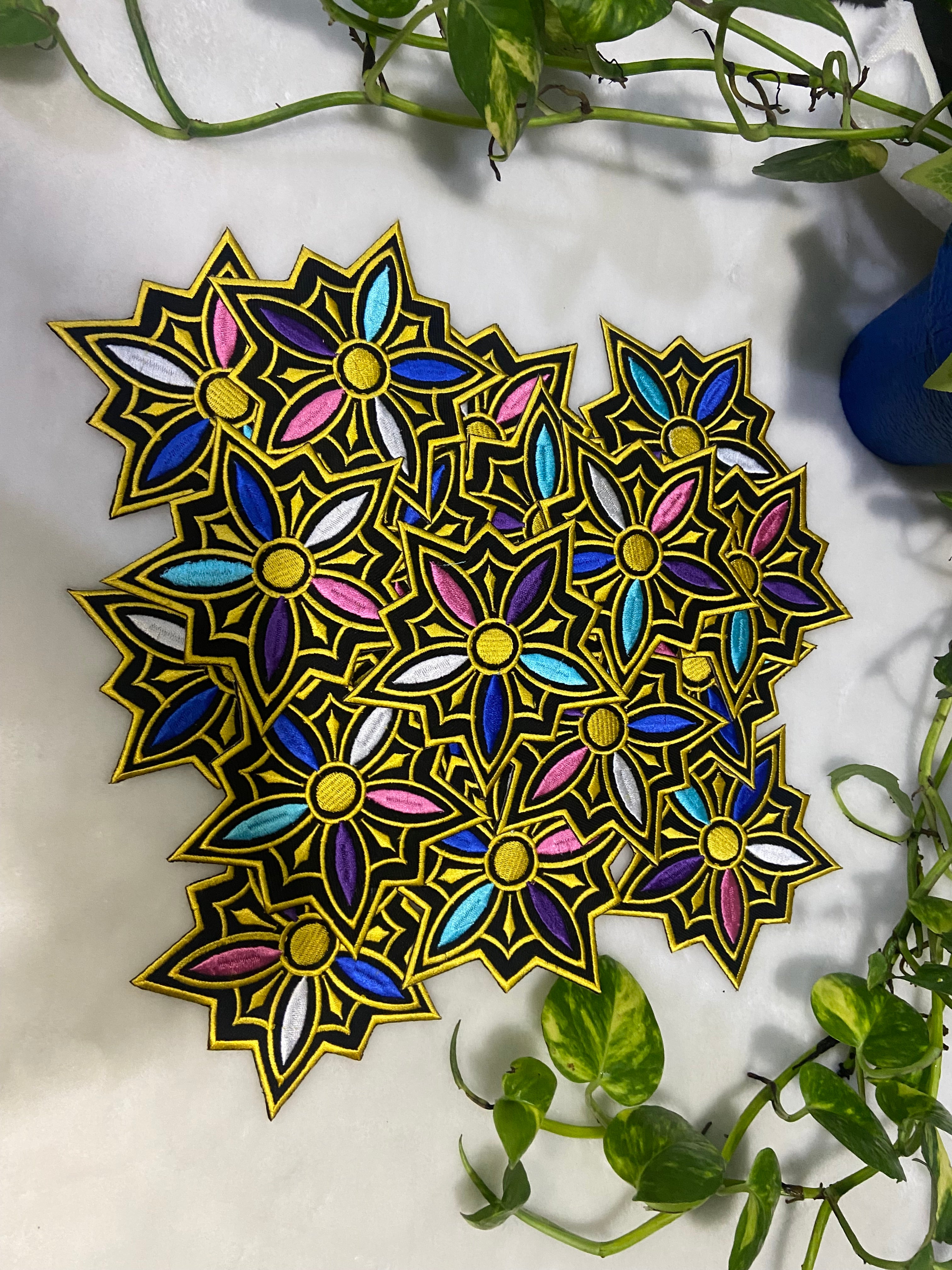 Colorful geometric design on a white surface with green leaves.