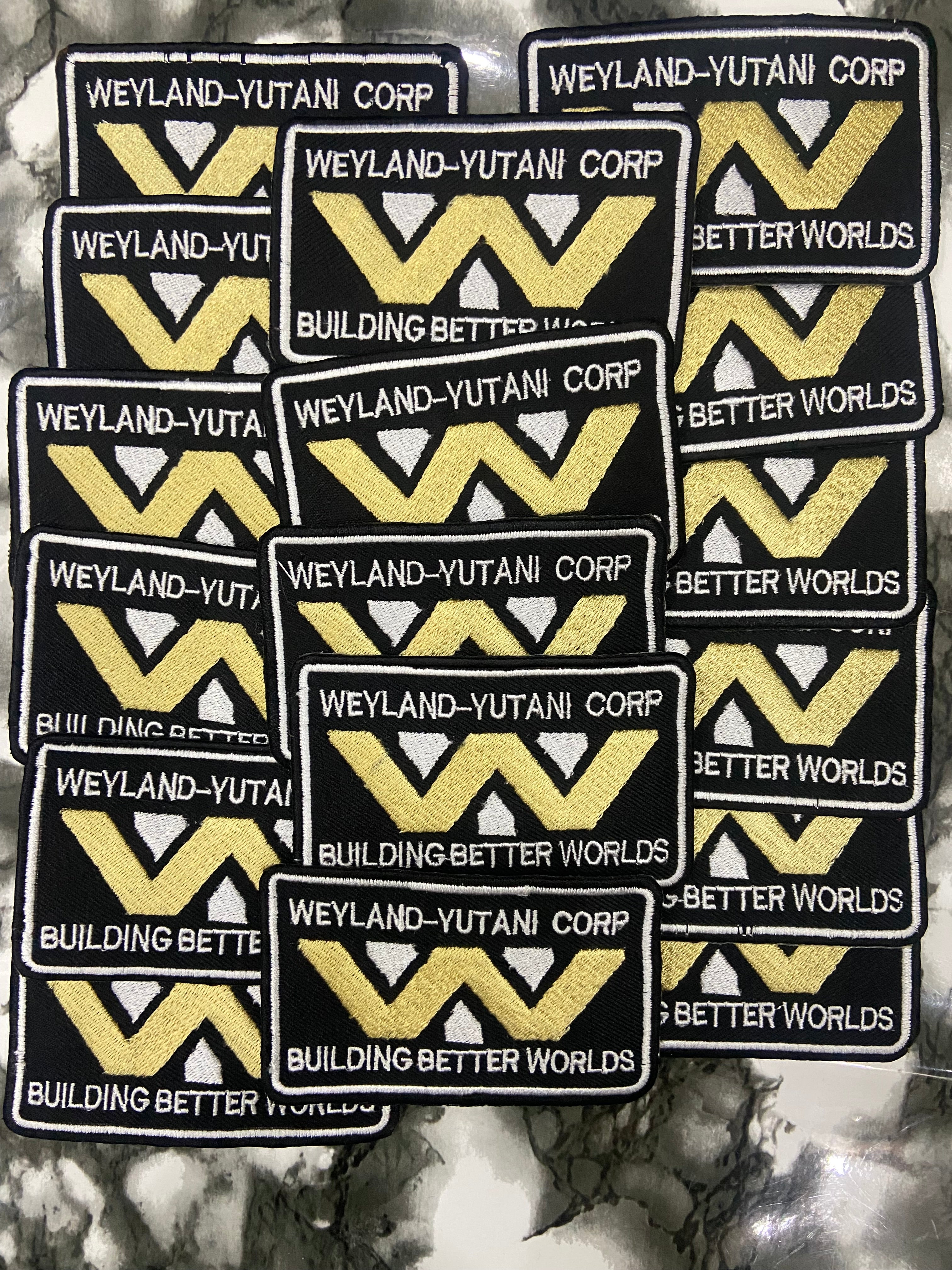 Multiple patches with Weyland-Yutani Corp logo and text on a textured background