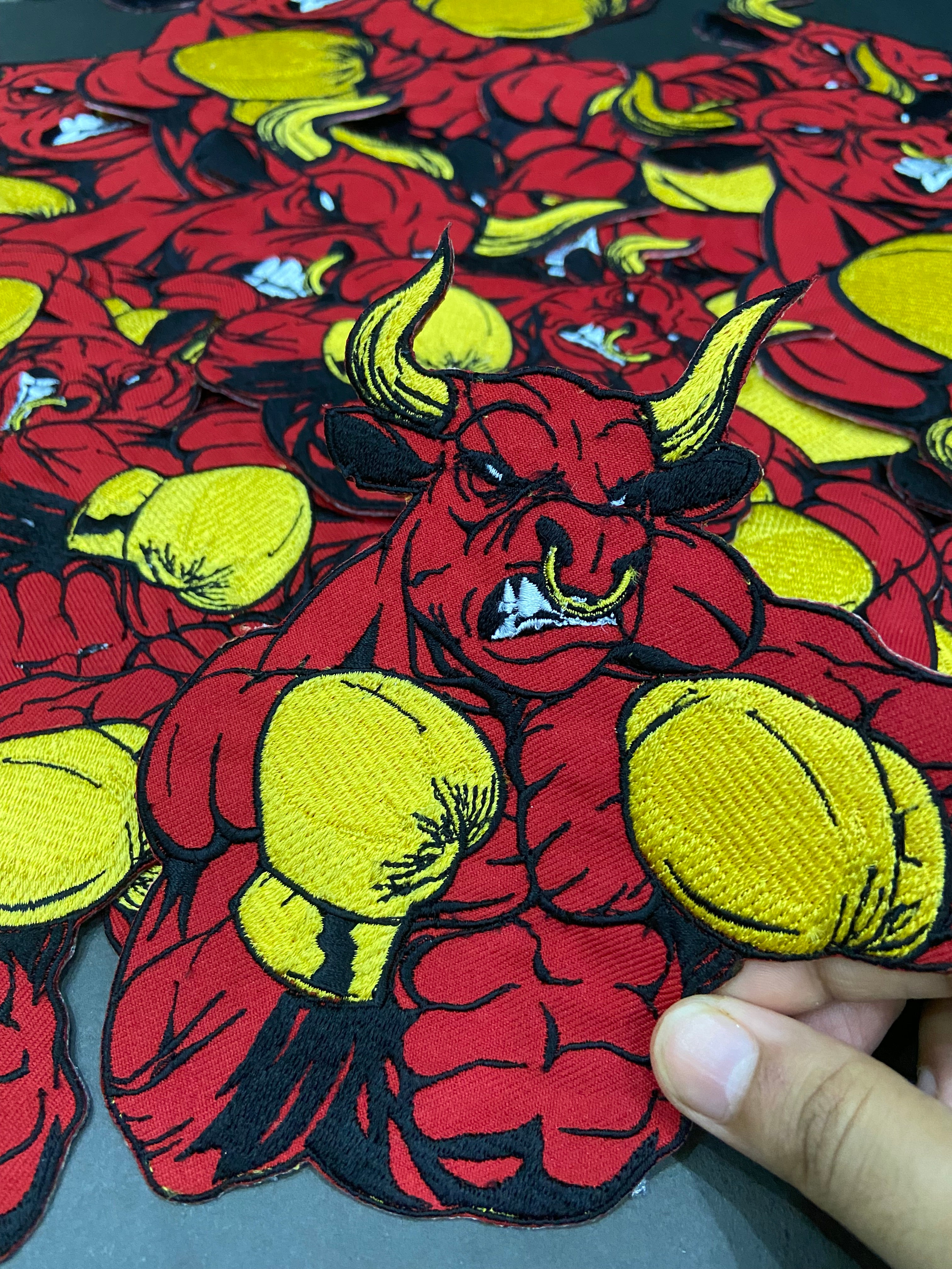 Close-up of a red and yellow patterned fabric with a hand holding it.