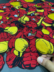Close-up of a red and yellow patterned fabric with a hand holding it.