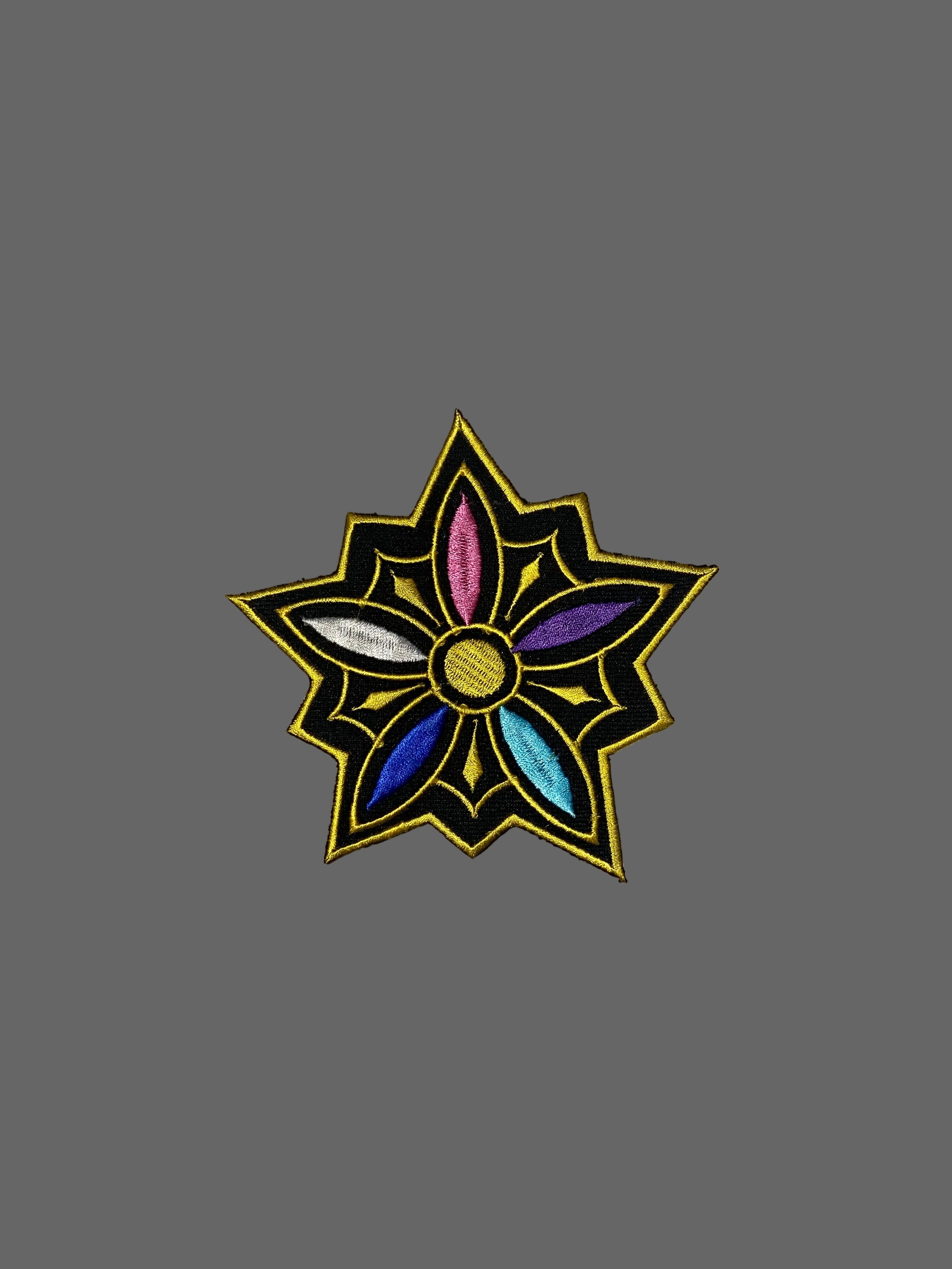 Decorative patch with a star-like design on a textured gray background
