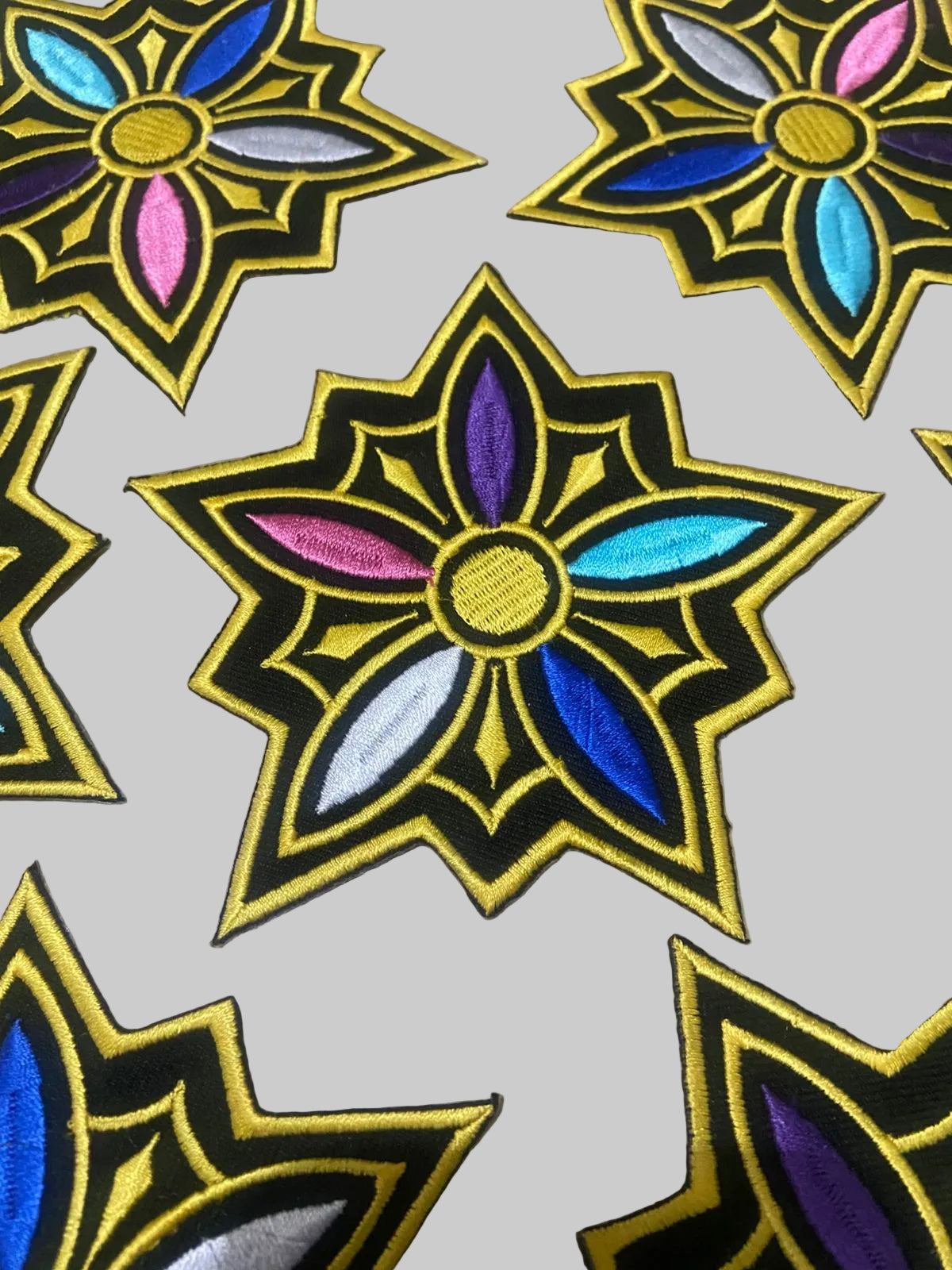 Decorative patches with colorful floral designs on a textured surface