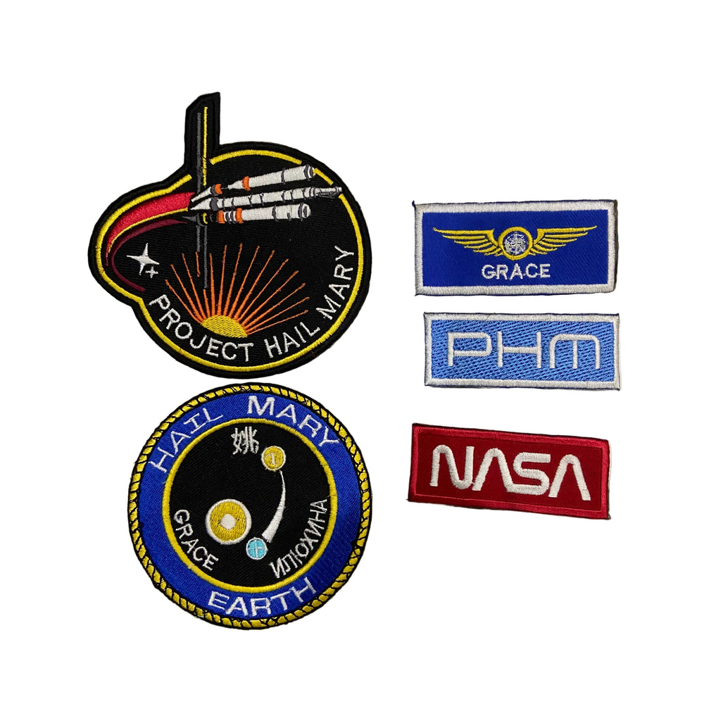 Collection of space-themed patches including 'NASA' and 'Project Hail Mary'.