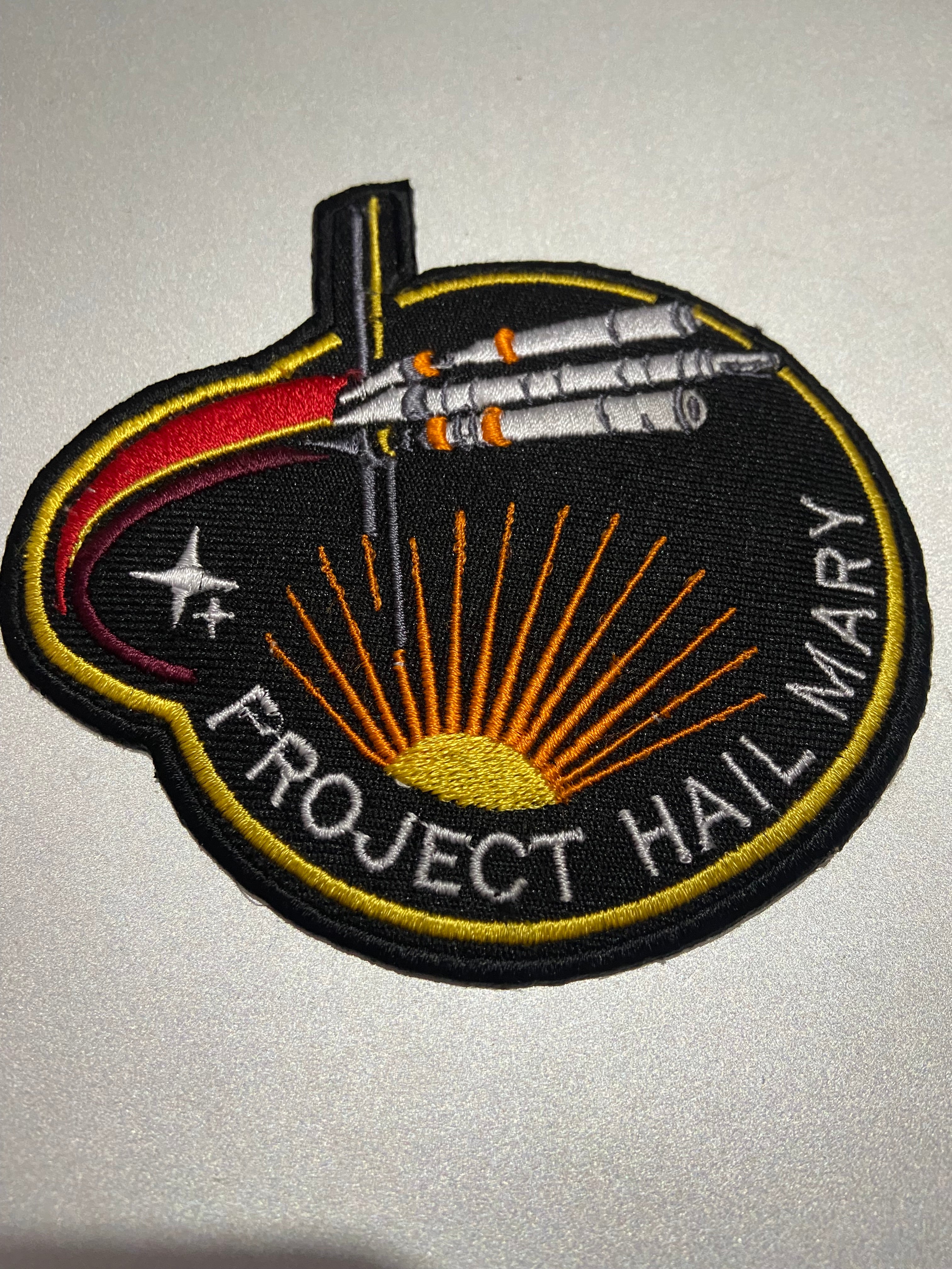 Embroidered patch with 'Project Hail Mary' design on a gray background
